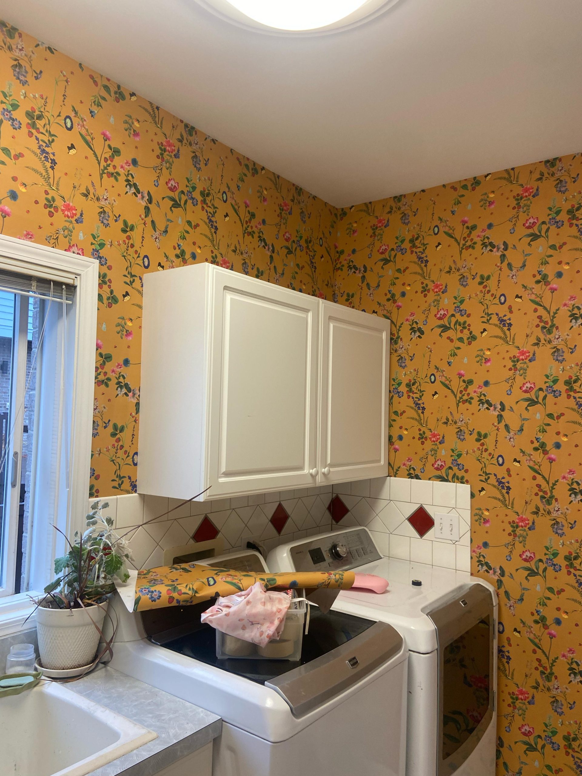 Technician removing wallpaper and skimming walls